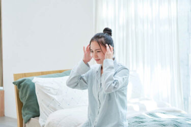 起床して頭痛がする女性画像